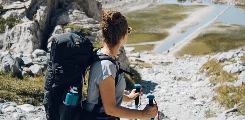 Mujer con maleta en la montaña