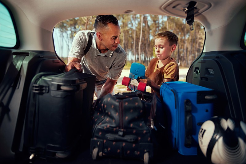 Padre e hijo preparando viaje en coche